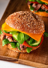 Beef burger with cheese, homemade nachos chips and spinach.