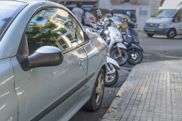 car and motorcycles Parking on the street  on a Sunny summer day