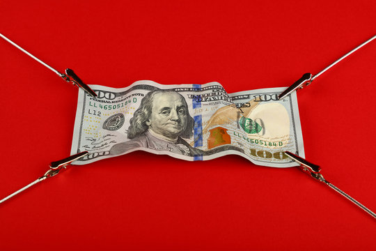 US dollar banknote stretched on red background
