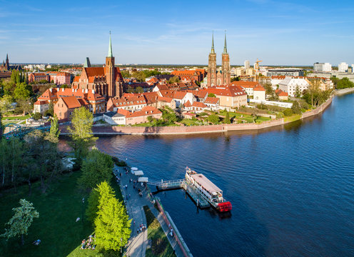 Poland. Wroclaw. Ostrow Tumski, Gothic cathedral of St. John the Baptist,  Collegiate Church of the Holy Cross, Archbishop's palace, tourist harbor, ship and Odra (Oder) River. Aerial view at sunset