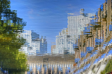 Reflection of severahl buildings and a tree in downtwon Rotterdam, The Netherlands, in the calm water of a canal