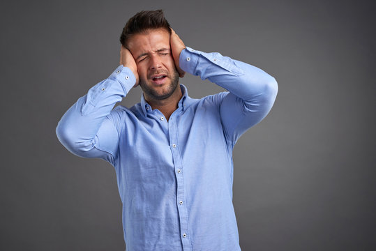 Young Man Grabbing His Head 	