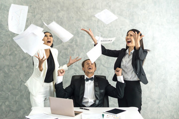 business people celebrating happy winner throwing papers on business office desk  , business success concept