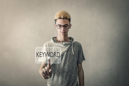 ragazzo che tocca schermo virtuale tasto keyword