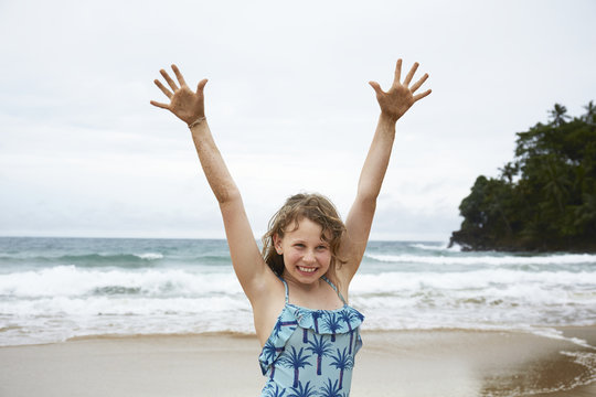 Girl with arms up on beach