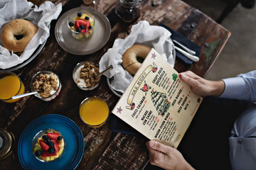 Midsection of man holding menu while having brunch at dining table