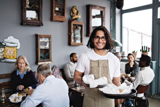 Portrait of waiter holding trays