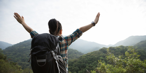 happy woman hiker enjoying the view on morning mountain valley