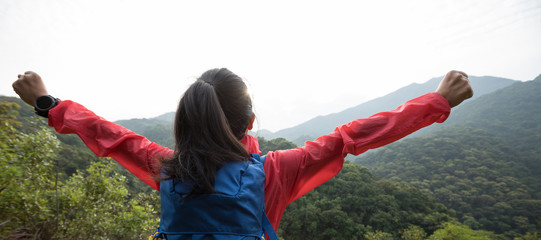 happy woman hiker enjoying the view on morning mountain valley