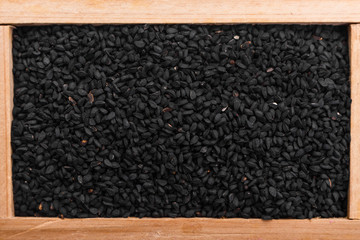 grains of black cumin and oil on the rustic background