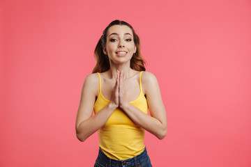 Smiling brunette woman in casual clothes praying with pray gesture