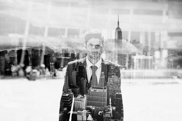 Monochrome double exposure of businessman portrait and New York skyline