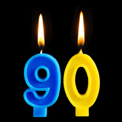 Burning birthday candles in the form of 90 ninety figures for cake isolated on black background....