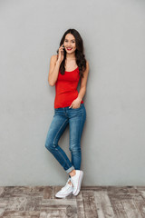 Full length image of Happy brunette woman in casual clothes