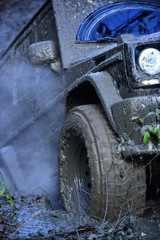 Part of SUV stuck in dirt, close up. Dirty tire