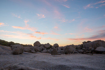 Fototapeta na wymiar Color cloud formations at sunset with rocks