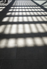 Lights and shadows on tiled floor by sunny day