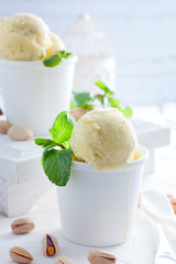 Homemade pistachio ice cream in white cups, selective focus