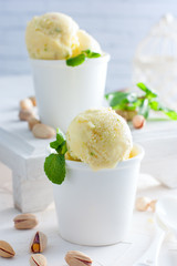 Homemade pistachio ice cream in white cups, selective focus