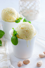 Homemade pistachio ice cream in white cups, selective focus