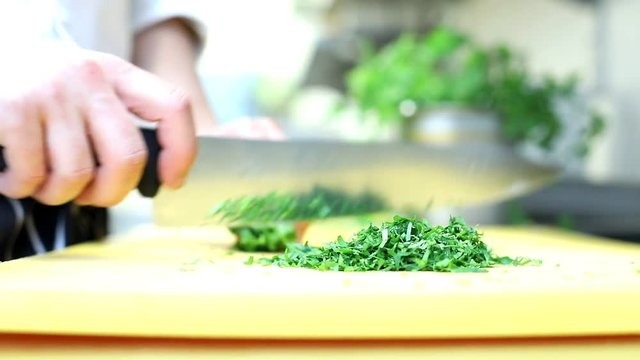 Chef slices greens for cooking in a restaurant
