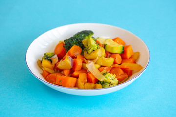 white plate with mixed vegetables on blue table