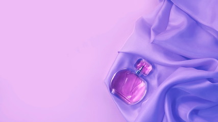 bottle of cosmetic liquid on satin. concept of beauty. toned background.