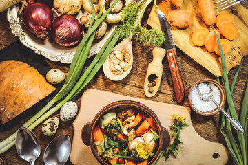preparation of spring dish dandelions with pumpkin and mushrooms. ingredients and spices. wooden background.