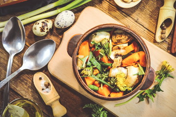 preparation of spring dish dandelions with pumpkin and mushrooms. ingredients and spices. wooden background.