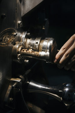 Artisan Hand Checking Coffee Beans in Vintage Roasting Machine