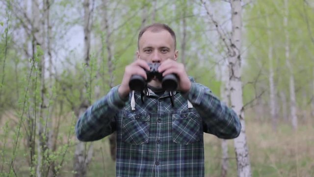 Tourist man looking through binoculars