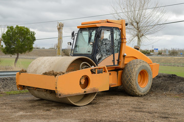 yellow asphalt paver parked at construction site