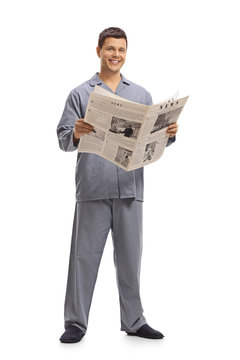 Young man in pajamas holding a newspaper