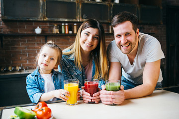 Family drink juice in the kitchen. Health care concept.
