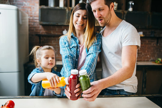 Family Drink Juice In The Kitchen. Health Care Concept.