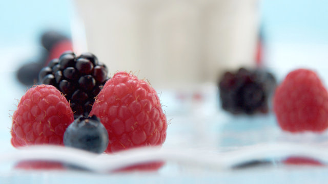 glasses with greek yogurt with berries Minimalism food on blue background. Panna cotta with strawberry raspberry, blueberry