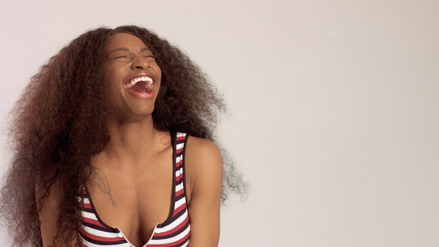 happy smiling laughing black mixed race woman in studio in top