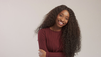 Beauty mixed race african american woman with hair blowed in air smiling at camera