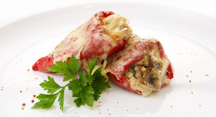 Stuffed Red bell peppers with mushrooms on the white plate.