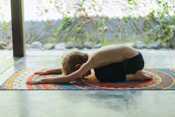 side view of adorable little kid practicing yoga in Extended Child (Utthita Balasana) pose