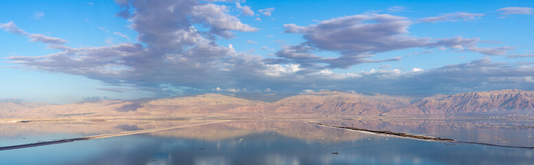 Obraz na płótnie Canvas Ecology disaster in Middle East, sunset with reflection over lowest salty lake in world below sea level Dead sea, disappearance of the sea due to shallowing
