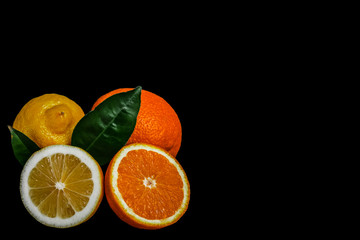 Fresh lemon and half, an orange and half with leaves isolated on black background.