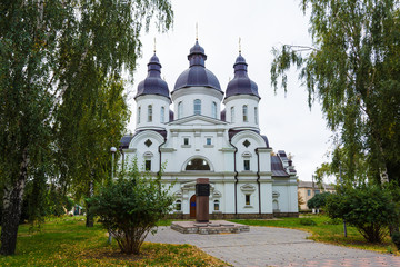 Fototapeta na wymiar Temple of St. Peter Kalnyshevsky in Nedryhailiv, Sumska oblast, Ukraine. Beautiful white building with domes for religious purposes, Orthodox Church.