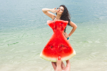 Young attractive woman on the beach relaxing. Pretty woman with watermelon. Cute girl outdoors