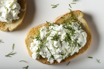 Appetizer with toast and homande cheese cream with fresh dill on plate