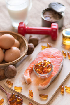 Natural source of vitamin D in Salmon, eggs, mushroom, fortified milk, margarine, canned tuna and fish oil capsule on wooden texture and background, healthcare and supplemental concept