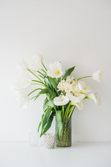 Large bouquet of white spring flowers in a vase, daffodils, tuli