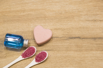 spa concept. pink bath salt and gel on the wooden background