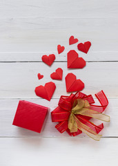 Red heart origami paper and present box on white woodern background, romance and Velentine's day concept