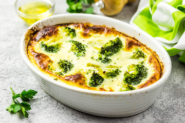 Broccoli egg cheese casserole in baking dish on concrete background. Selective focus, space for...